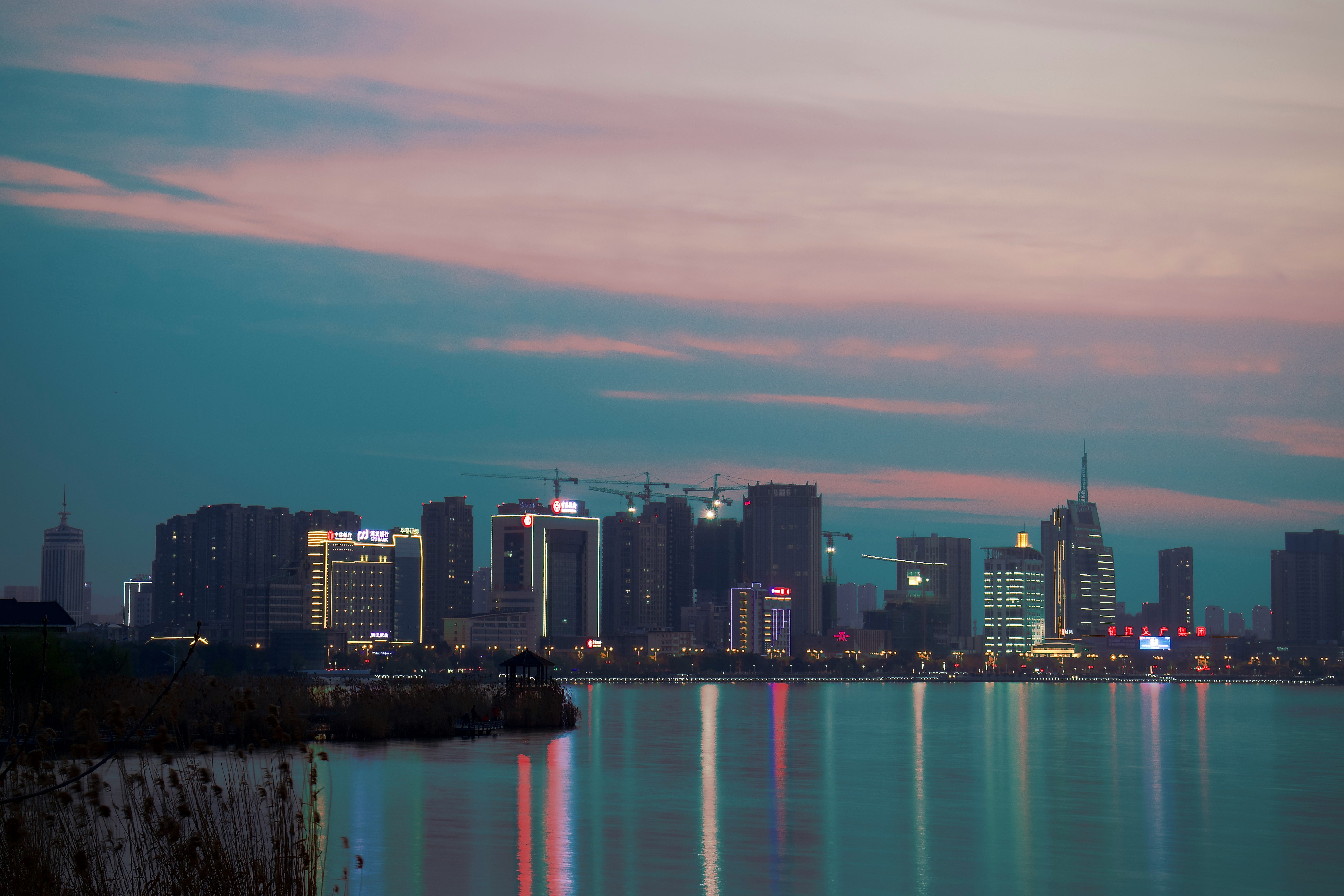 city skyline near body of water during night time